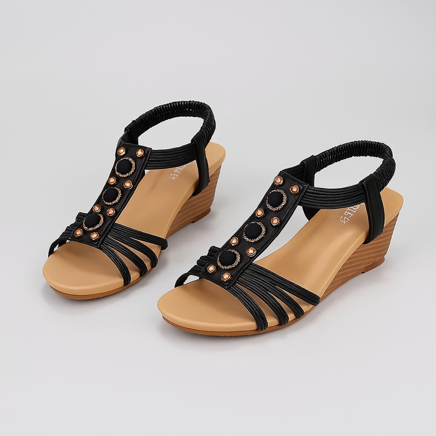 Black strappy sandals with brown soles on a light gray background