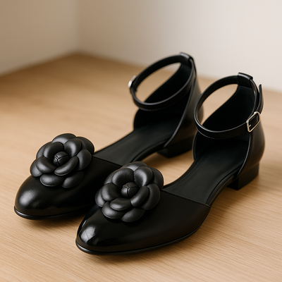 Black shoes with floral embellishments on a wooden surface