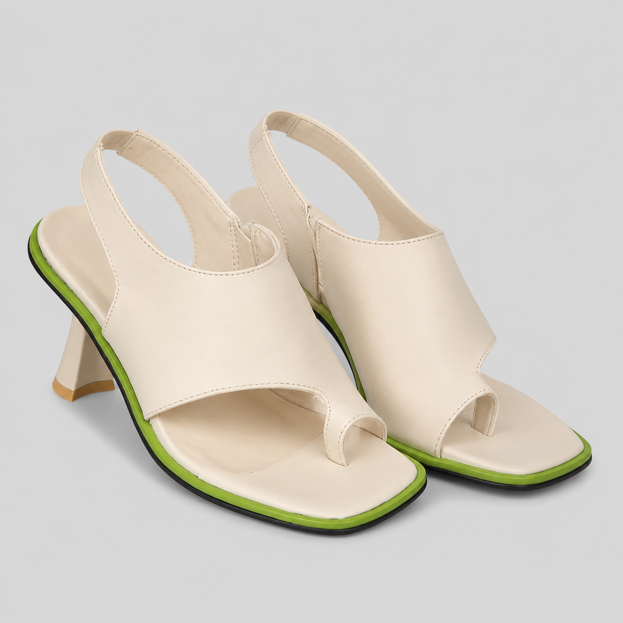 Beige high-heeled sandals with green trim on a light gray background
