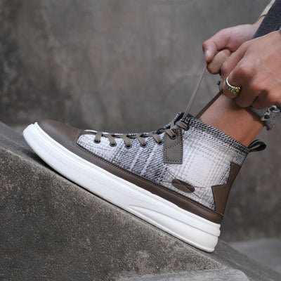 Brown and white sneaker with patterned side on a gray background