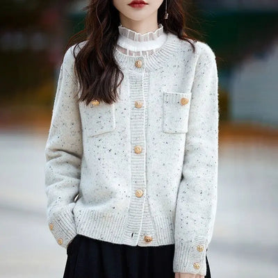 Woman wearing white knit cardigan sweater with round neck and pockets