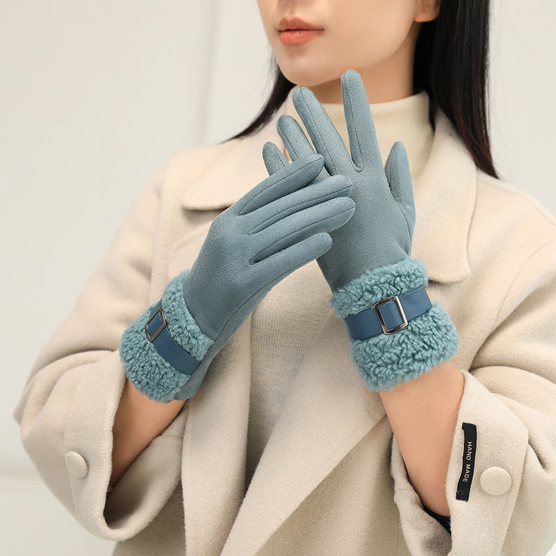 Person wearing blue gloves with fur trim on a plain background