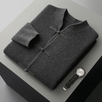 Folded gray garment on a light surface with a watch beside it