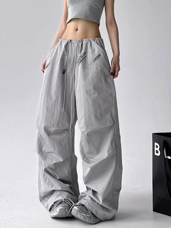 Person wearing gray wide-leg pants on a plain background