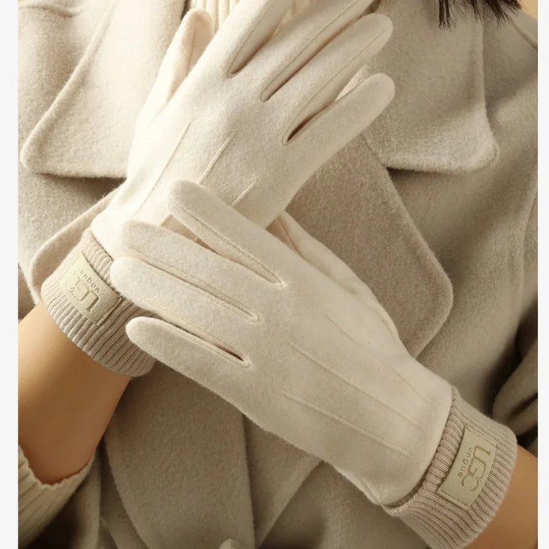 Beige gloves worn by a person against a neutral background