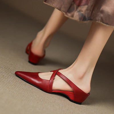 Red high-heeled shoes worn on a neutral background