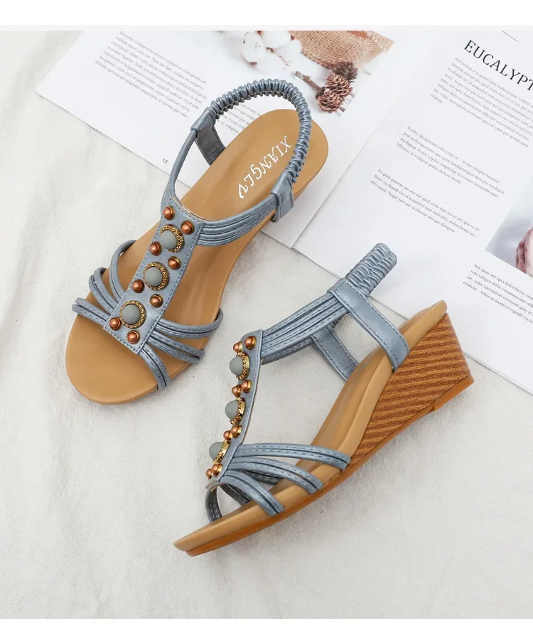 Pair of sandals with decorative straps on a light background
