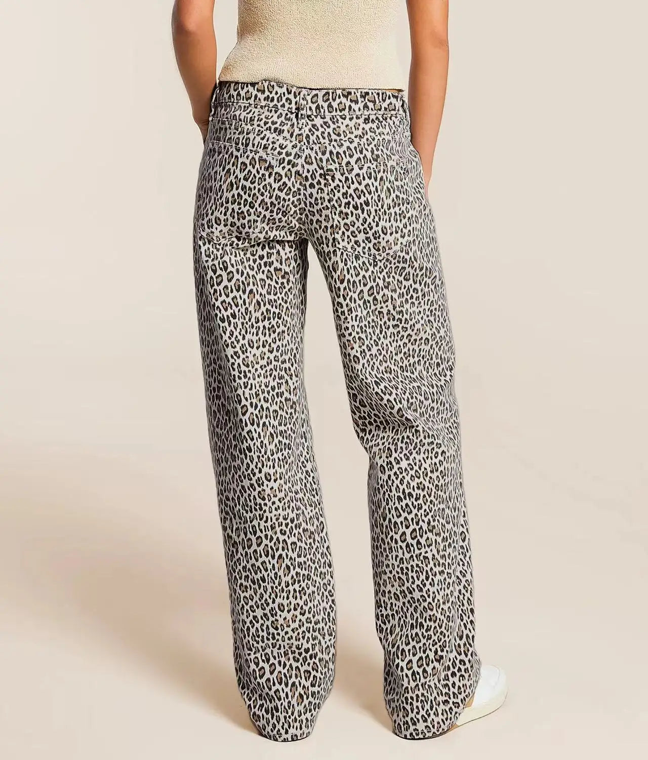 Leopard print pants worn by a person on a beige background