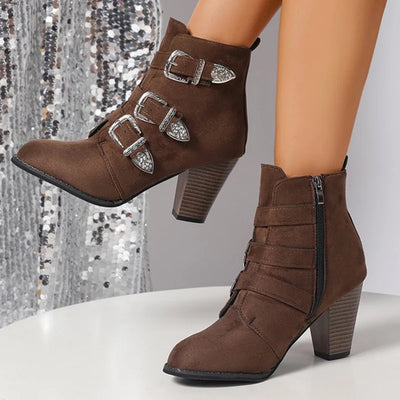Brown ankle boots with buckles on a neutral background