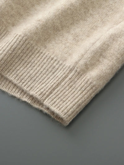 Close-up of a beige knitted sweater on a gray background