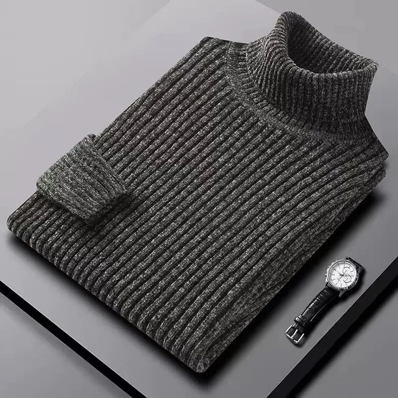 Gray ribbed sweater on a gray surface with a watch next to it