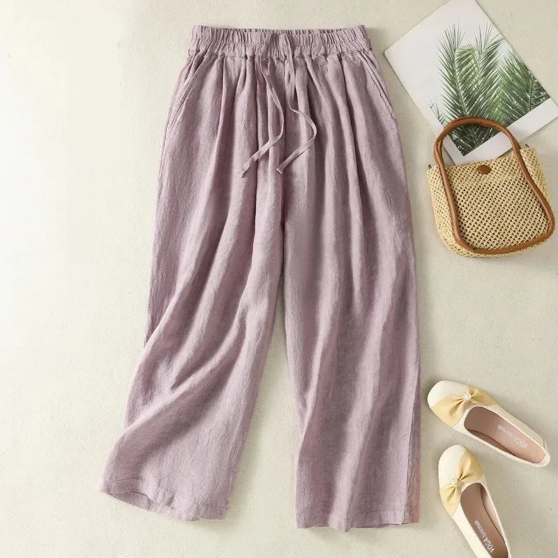 Purple pants with a woven bag and shoes on a light background