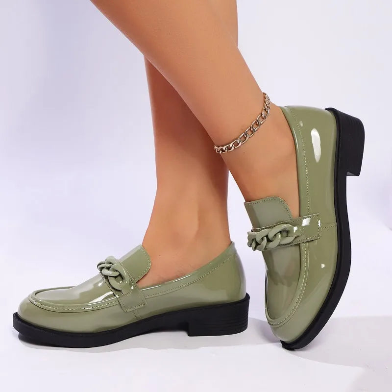 Green loafers worn on feet with a white background