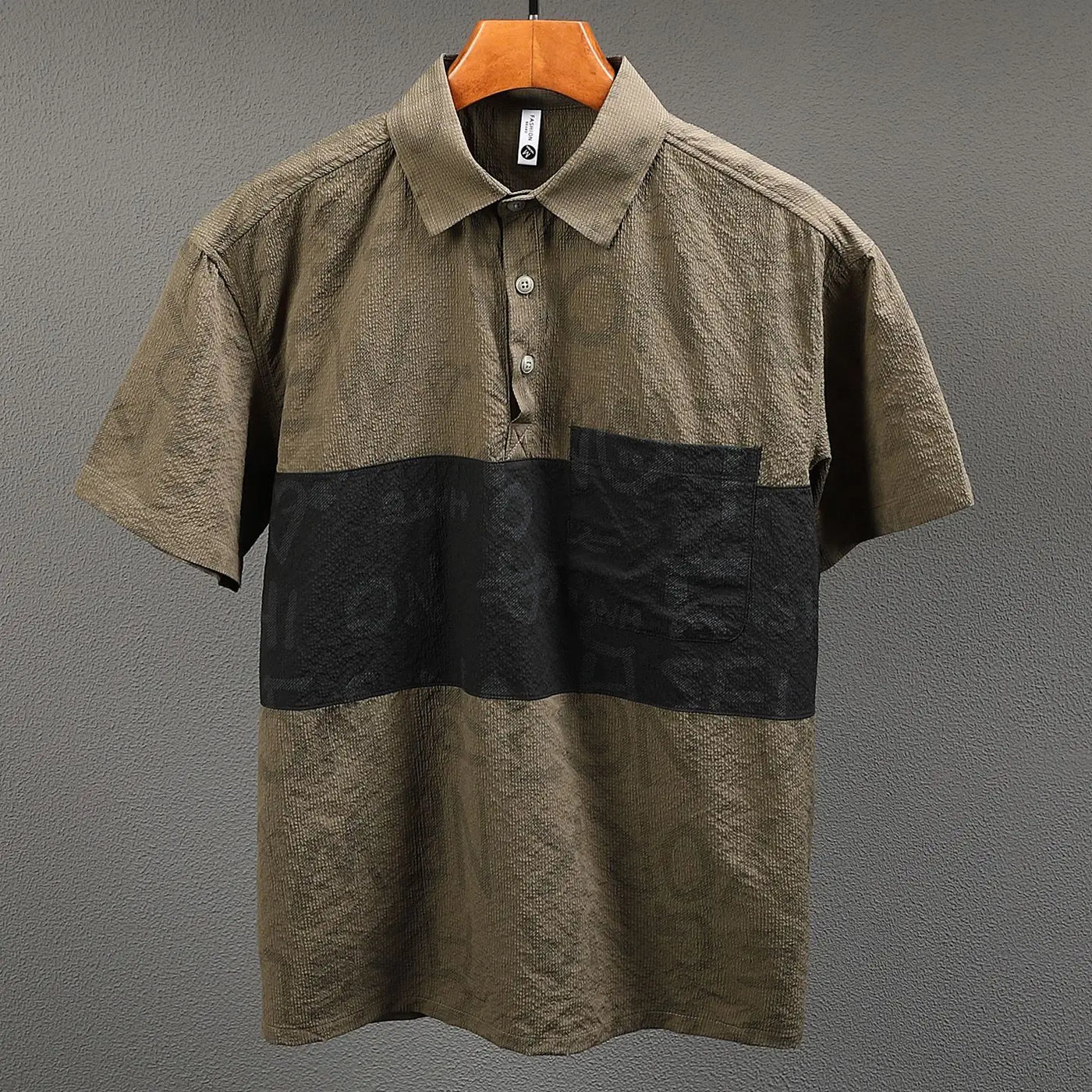 Two-tone brown and black polo shirt on a gray background
