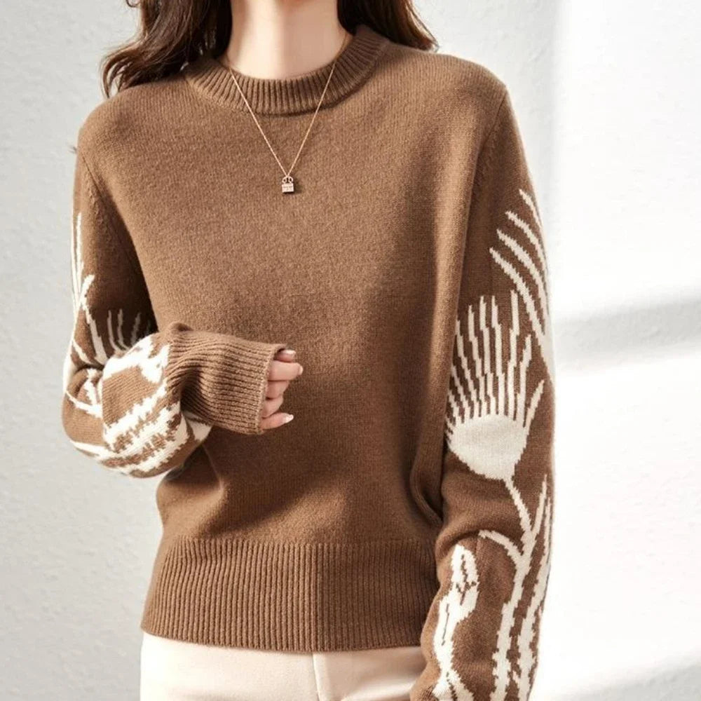 Brown sweater with white pattern on sleeves against a neutral background