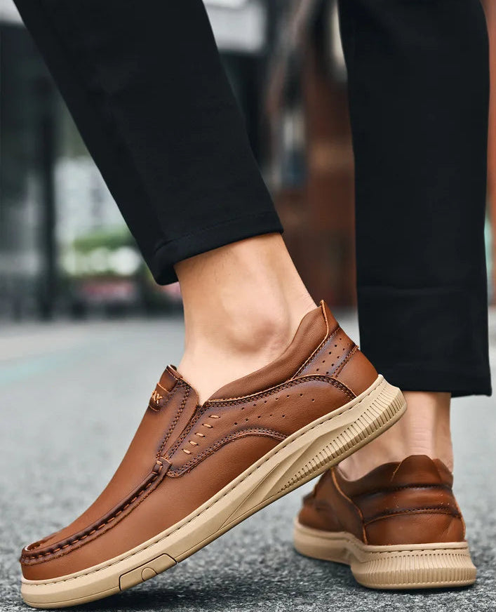 Brown leather shoes worn with black pants on a blurred street background