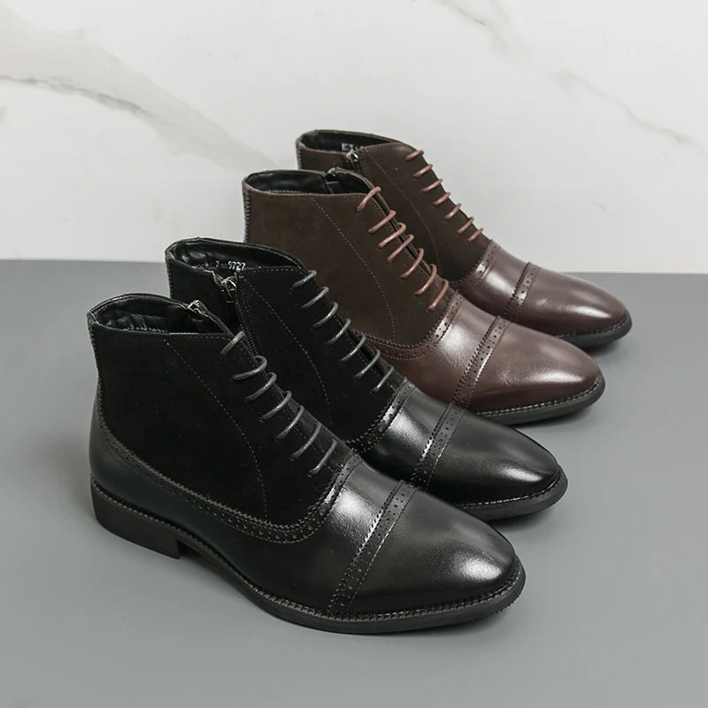 Pair of black and brown leather ankle boots on a gray surface with a white background
