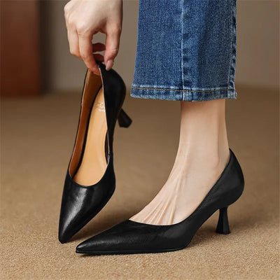 Black high-heeled shoes being worn with a blurred background