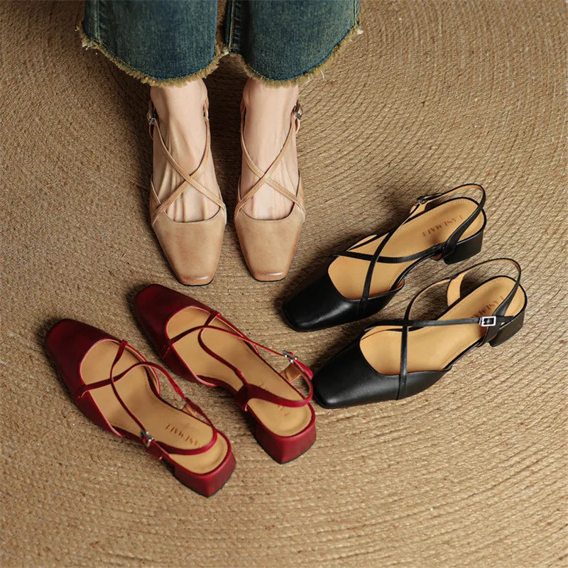 Four pairs of women's shoes in beige, red, and black on a textured surface.