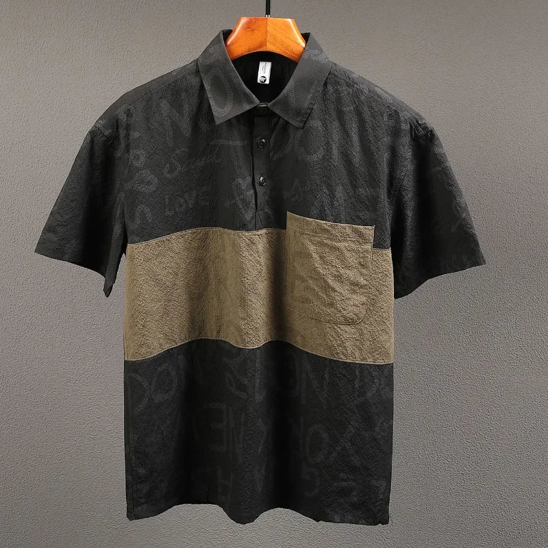 Two-tone black and brown polo shirt on a hanger against a gray background
