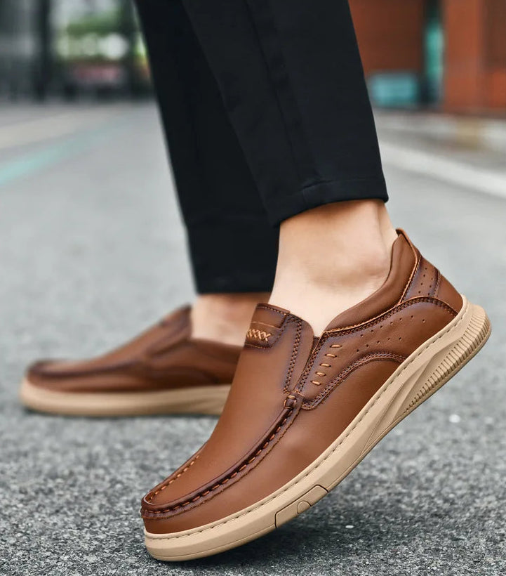 Brown leather shoes worn on a blurred street background