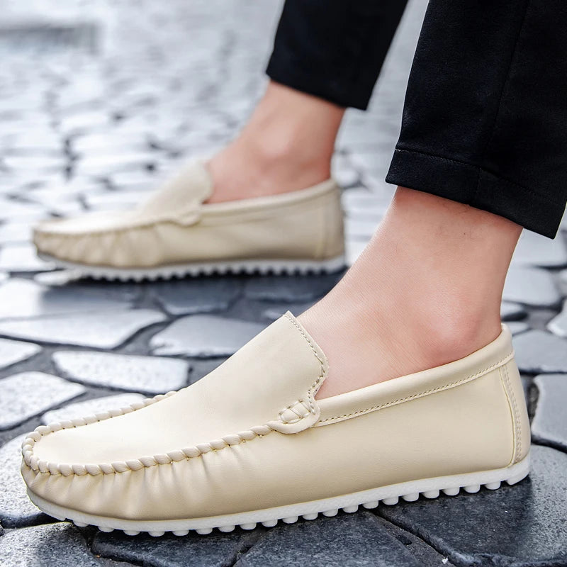 Beige loafers worn on a stone pavement