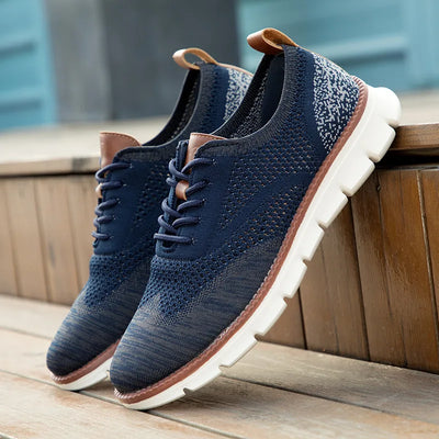 Pair of navy blue sneakers with brown accents on a wooden surface