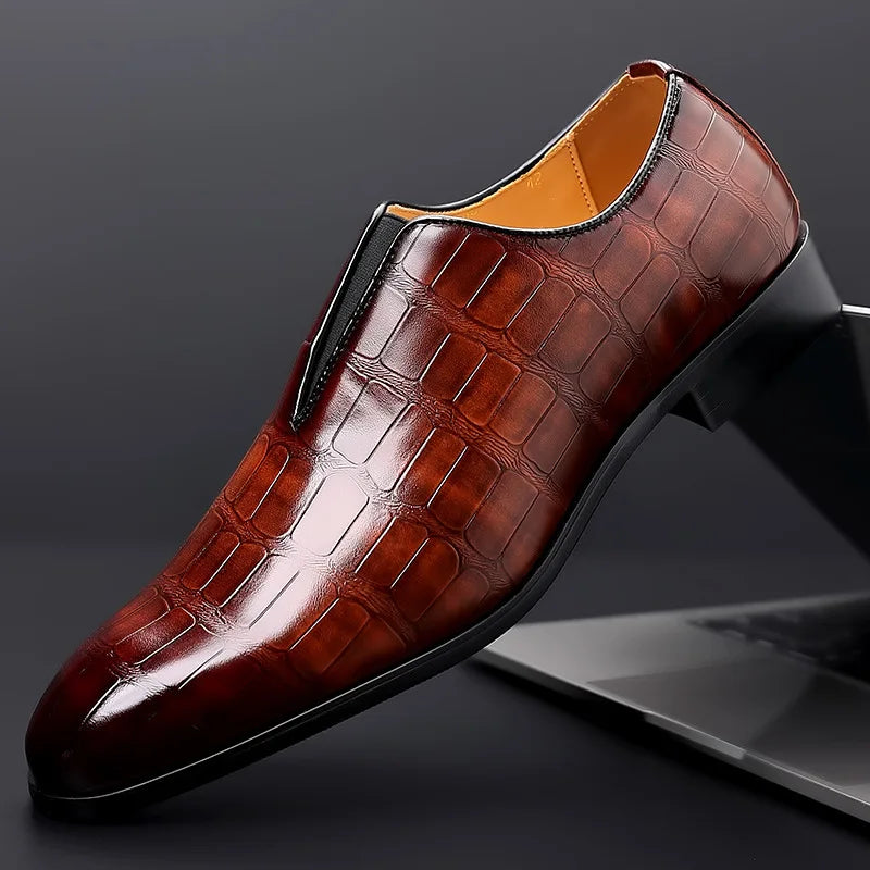 Brown leather dress shoe with crocodile pattern on a dark background