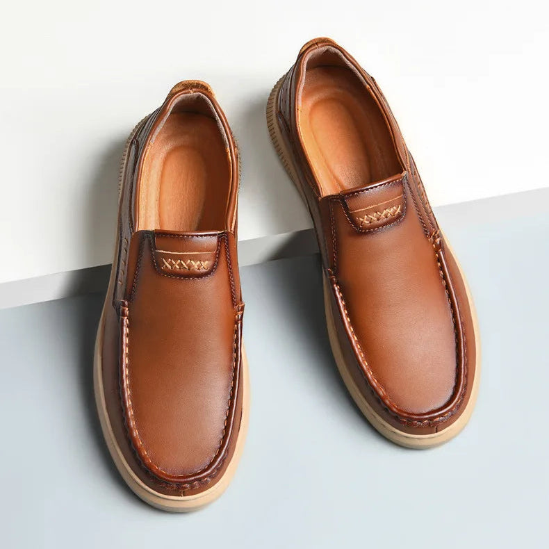 Pair of brown leather shoes on a light gray background