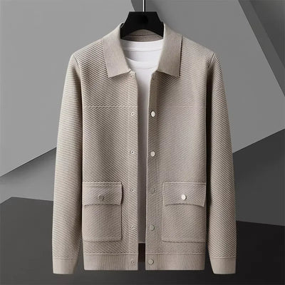 Beige jacket on a hanger against a gray background