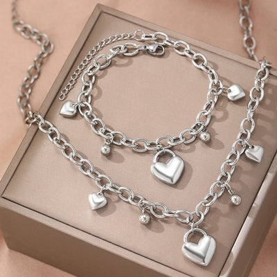 Silver chain bracelet with heart-shaped charms on a beige box