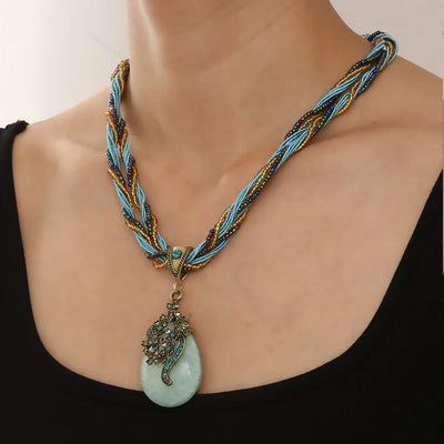 Necklace with braided design and turquoise pendant on a mannequin