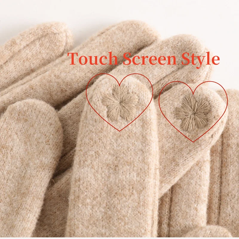 Close-up of beige gloves with heart-shaped touch screen areas on a light background