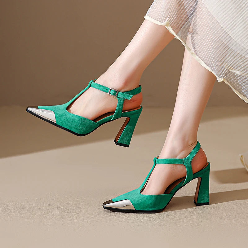 Green high-heeled shoes worn by a person on a beige background