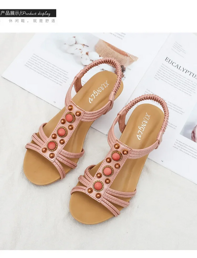 Pair of pink sandals with decorative elements on a white background
