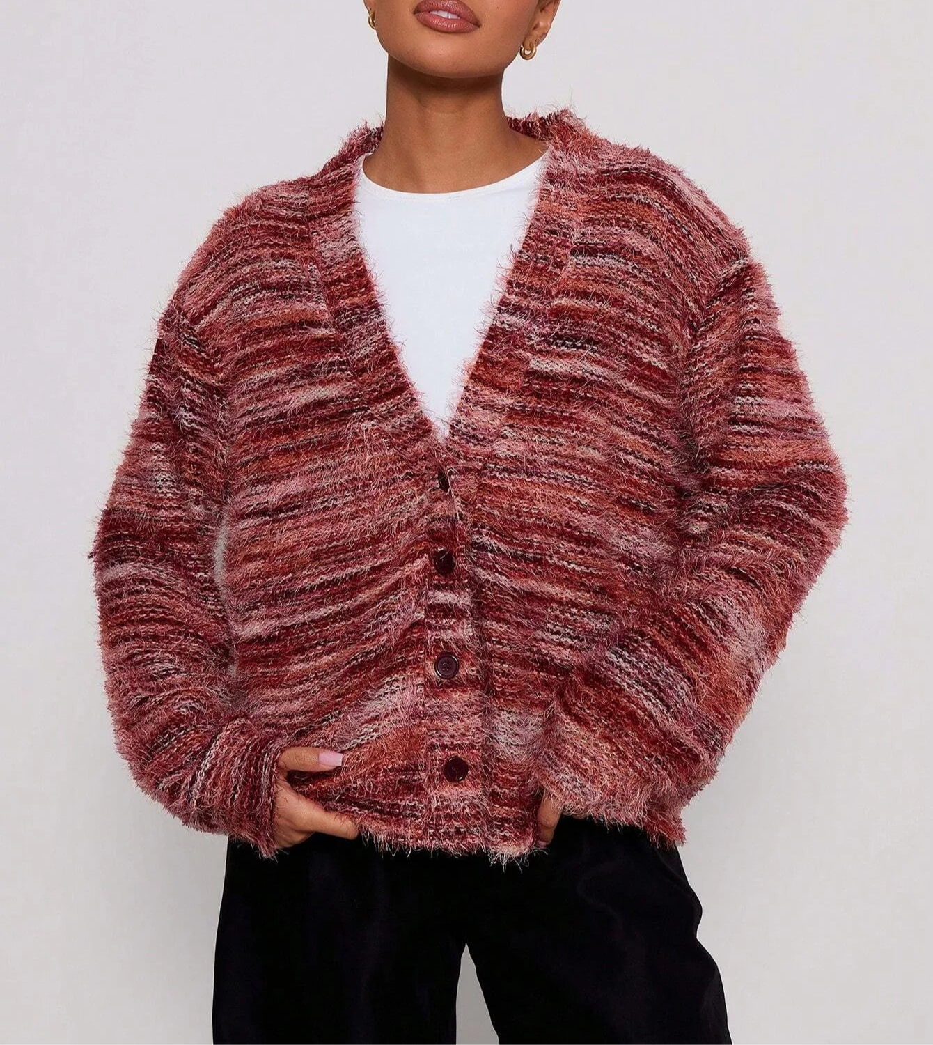 Person wearing a textured pink cardigan on a white background