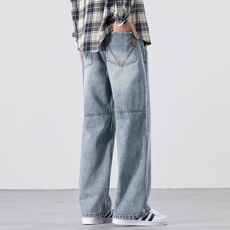 Person wearing light blue jeans and a plaid shirt on a plain background