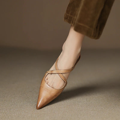 Brown leather pointed-toe shoe with criss-cross strap on a neutral background