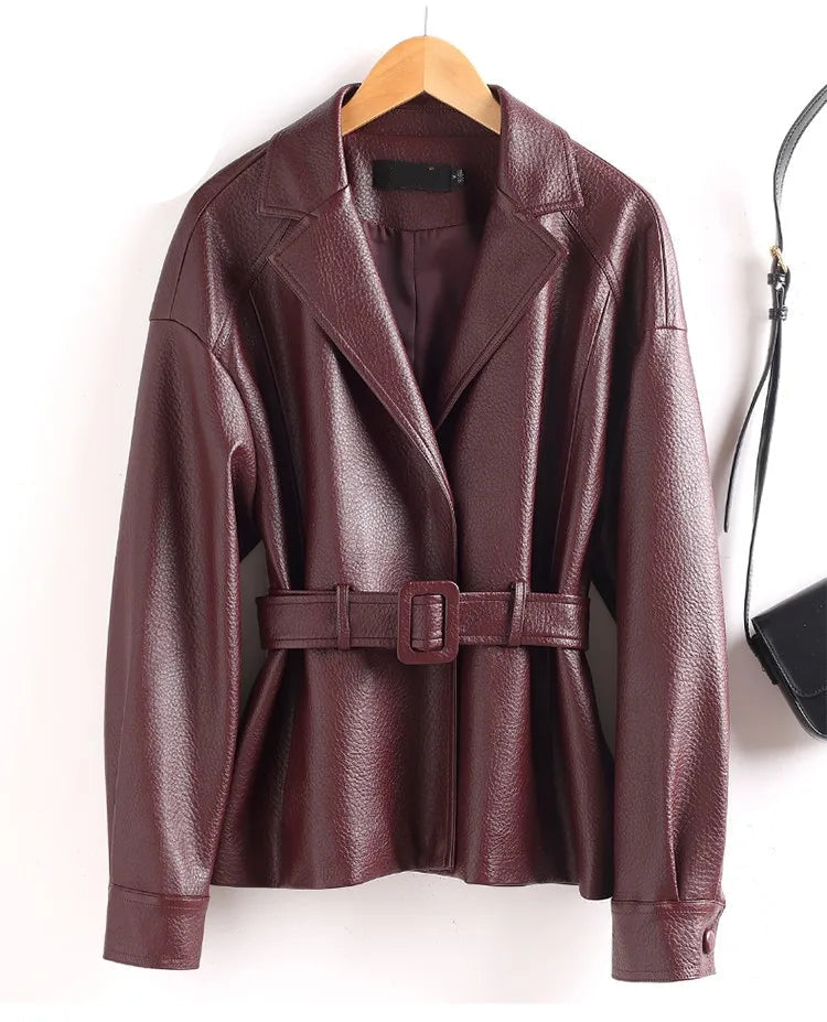 Brown leather jacket with a belt on a hanger against a white background