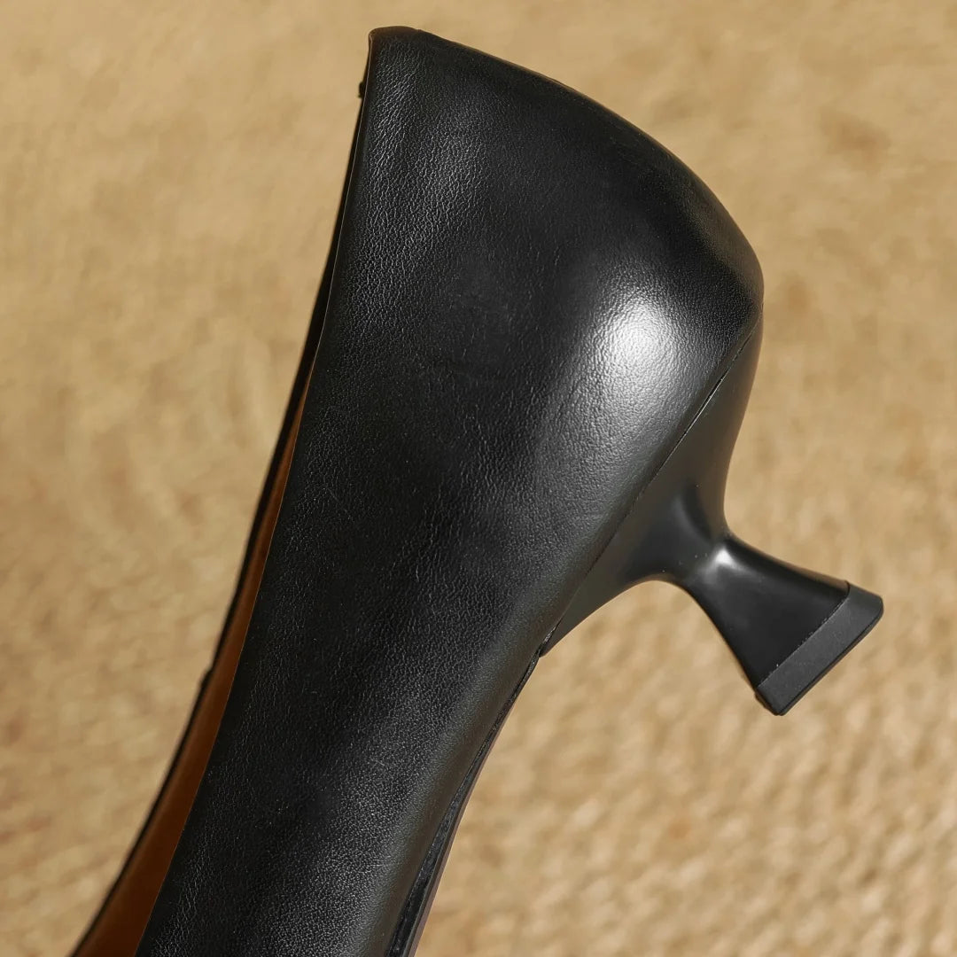 Black high-heeled shoe on a beige background
