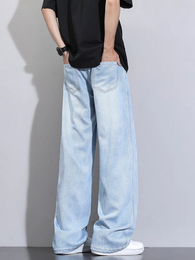 Person wearing light blue jeans and a black shirt against a plain background