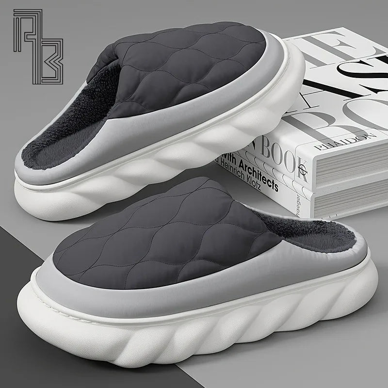 Pair of black and white slippers on a gray surface with a magazine in the background.