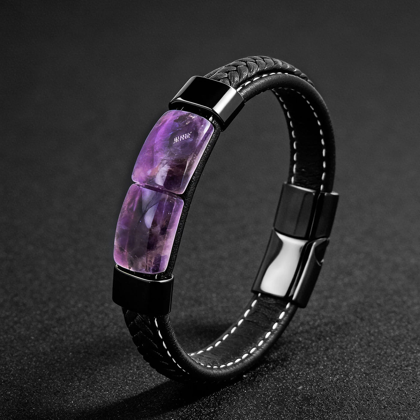 Black leather bracelet with purple gemstones on a dark background