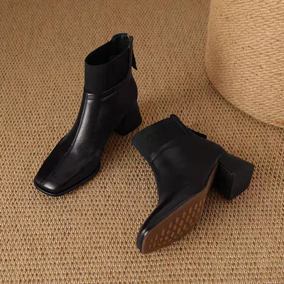 Black ankle boots on a textured brown surface