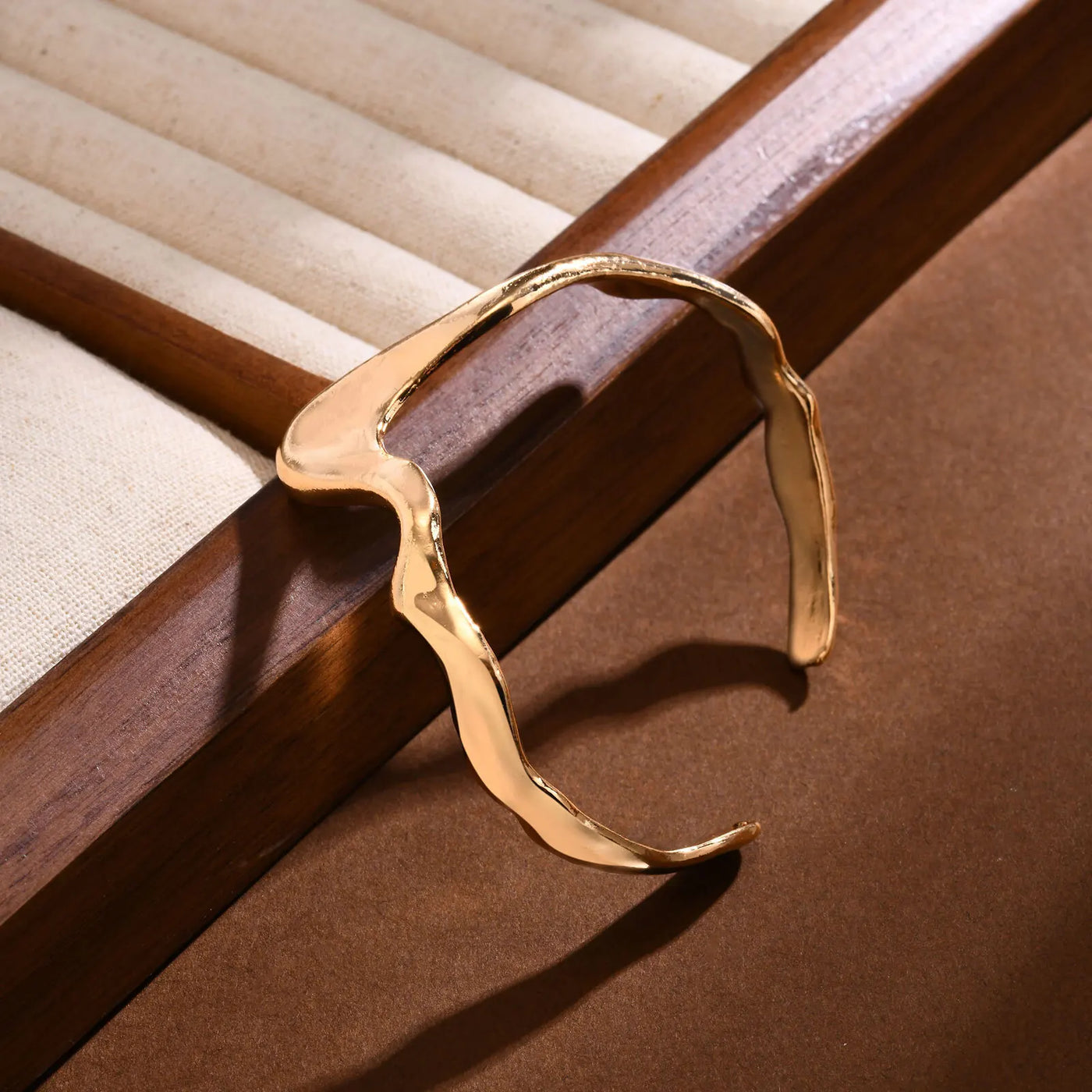 Gold bracelet on a wooden surface