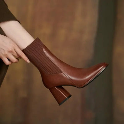 Brown ankle boot being held with a blurred background