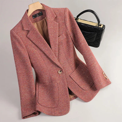 Pink blazer on a mannequin with a black handbag in the background