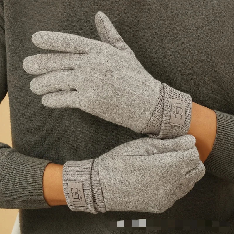 Gray gloves worn by a person against a dark background