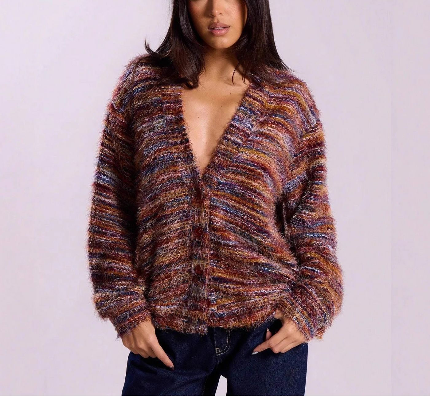 Woman wearing a patterned cardigan against a plain background