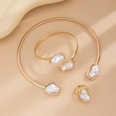 Gold bracelet with pearl-like stones on a beige fabric background